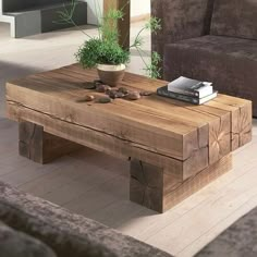 a wooden table sitting on top of a hard wood floor next to a brown couch