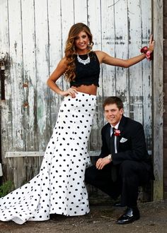 a man kneeling down next to a woman in a polka dot skirt and crop top