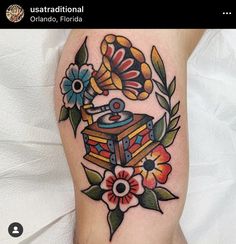 a colorful tattoo with an old record player and flowers