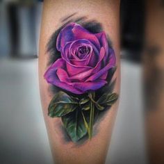 a purple rose tattoo on the leg