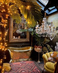 an ornate bathroom decorated in gold and green with chandelier, bathtub, rugs, and palm trees