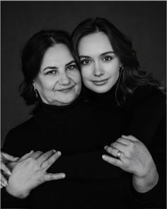 two women hugging each other with their arms around one woman's neck and fingers on her chest