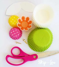 cupcake liners, paper flowers and scissors on a table