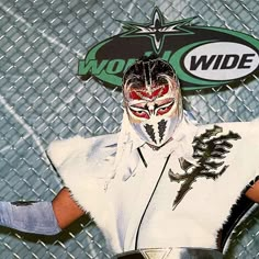 the wrestler is posing for a photo with his hands on his hips and face painted red