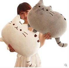 a woman holding a large stuffed cat in her hands