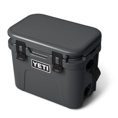 a gray yeti cooler with black handles and latches on the lid is shown in front of a white background