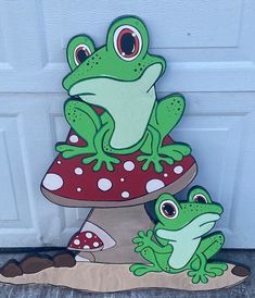 two green frogs sitting on top of a mushroom