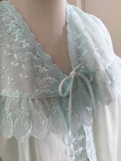 True vintage ice blue bed jacket or baby doll top?  Has one single tie as closure in the front. Very pretty embroidered detail.  No tags so please use measurements.  Assumed to be nylon but could be a blend.  Adorable sleeves! Chest is 18 inches flat Sleeve length is 12 inches Across shoulders at back is 14-15 inches Length is 26-27 inches Very pretty vintage jacket or top!   Final sale. Please ask questions.  No returns. Blue Bed, Bed Jacket, Baby Blue Aesthetic, Baby Doll Top, Floral Robes, Dress Up Dolls, Women's Nightgowns, Blue Bedding, Vintage Vanity