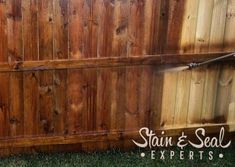 a fire hydrant spraying water on a wooden fence that says stain & seal experts