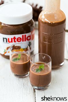 two glasses filled with chocolate pudding next to a bottle of nutella