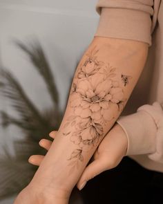 a woman with a flower tattoo on her arm