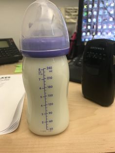 a baby bottle sitting on top of a wooden desk