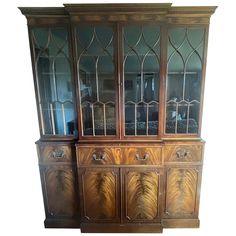 an old wooden china cabinet with glass doors