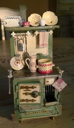 an old fashioned toy stove with pots and pans on it's burner