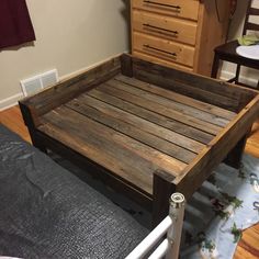 a bed frame made out of wooden pallets in a room with hardwood flooring