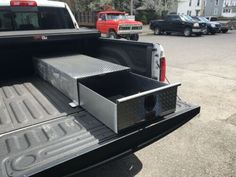 the back end of a pickup truck with its flatbed open and storage compartment opened