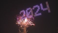 fireworks are lit up in the night sky above a large sign that reads seoul on it