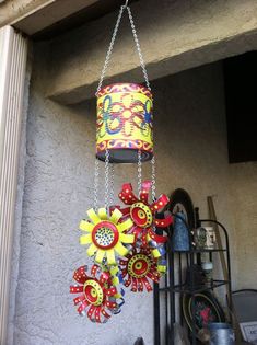 a colorful wind chime hanging from the side of a building next to a window