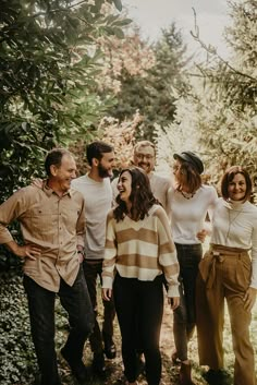 a group of people standing next to each other on a field with trees in the background