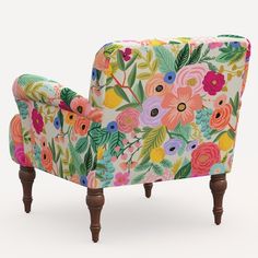 an upholstered chair with colorful flowers and leaves on the back, against a white background