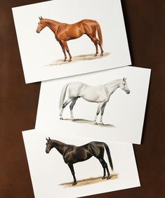 three different colored horses standing next to each other on top of a brown tablecloth