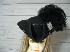 Beautiful ladies all black woolen pirate hat with black venise lace surrounding the brim of the hat with clear glass rhinestones at each point of the lace. Black ostrich feathers, black cocarde with large sparkly jewel. This hat is 22.5" for the inside circumference with a built-in hat sizer. Just cinch and tie. Please measure your head as I cannot make the circumference bigger so please keep that in mind. This is not an oversized brim pirate hat. The upturn brim is about 4". All sales are final. Check out my other pirate hats and goodies in my shop. Please let me know if you have any questions.   All sales are FINAL, no returns or exchanges please keep this in mind before purchasing. Pirate Captain Hat, Witch Brooms, Halloween Witch Brooms, Tricorn Hat, Black Pirate, Pirate Fairy, Pirate Halloween, Pirate Hat, Pirate Hats