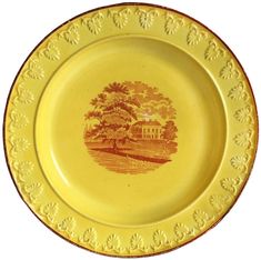 a yellow and brown plate with an image of a house on it