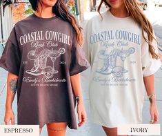 two women walking down the street wearing t - shirts that say costal cowgirl