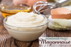 a glass bowl filled with cream sitting on top of a wooden table