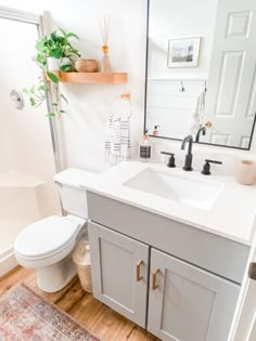 a bathroom with a toilet, sink and mirror