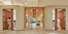 a man walking down a hallway between two doors