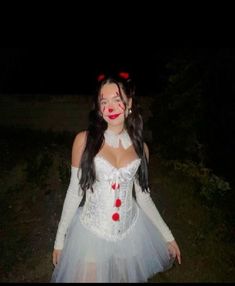 a woman dressed up as a clown in the dark