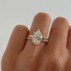 a woman's hand with a diamond ring on top of her finger, showing the side view