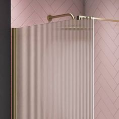 a bathroom with pink walls and a gold shower head