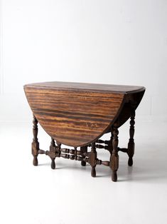 an old wooden table with two legs on the top and one leg raised to the side