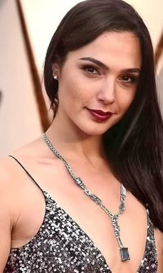 a woman with long dark hair wearing a black and white dress posing for the camera