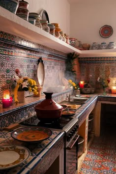 a kitchen filled with lots of counter top space and colorful tiles on the wall above it