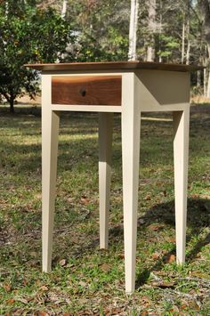 a small wooden table sitting in the grass