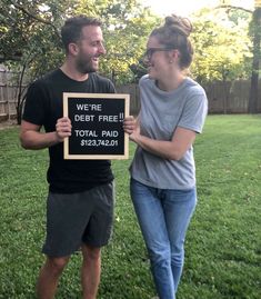 a man and woman holding a sign that says we are debt free