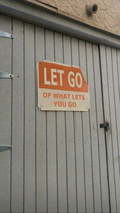 a sign on the side of a building that says let go of what lets you go