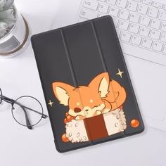 an ipad case with a cartoon fox on it next to a keyboard and eyeglasses