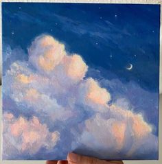 a person holding up a painting of clouds and the moon in the sky above them