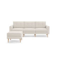 a white couch and footstool sitting next to each other on a white background