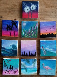 six small paintings are displayed on a wooden table