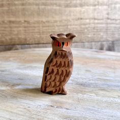 an owl figurine sitting on top of a wooden table