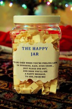 a jar filled with lots of yellow paper on top of a rug next to a christmas tree