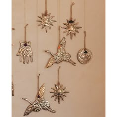 a group of metal birds hanging from hooks on a wall with sun and moon decorations