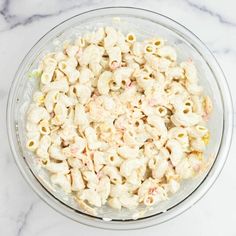 a bowl filled with macaroni and cheese on top of a marble counter