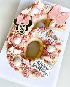 a pink and white mickey mouse birthday cake