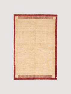 a beige rug with red border on top